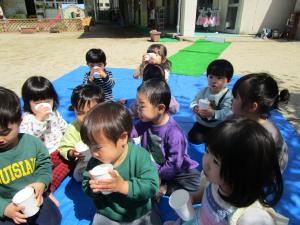 ２歳うさぎ組　戸外でおやつやジュースを飲む様子