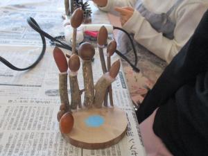 木の上にどんぐりをのせている子ども