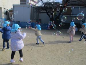 しゃぼん玉を追いかけている3歳児