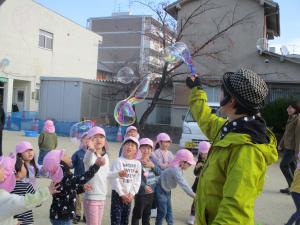 しゃぼん玉おじさんと遊んでいる4歳児