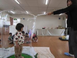 しゃぼん玉に入る2歳児女の子