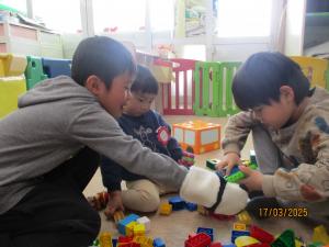 玩具で一緒に遊ぶ1歳児と5歳児　2