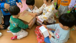クリスマスの箱を開ける2歳児
