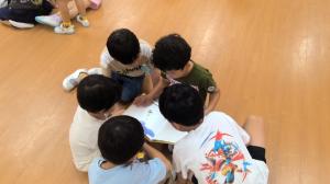 みんなで本を見てる5歳児